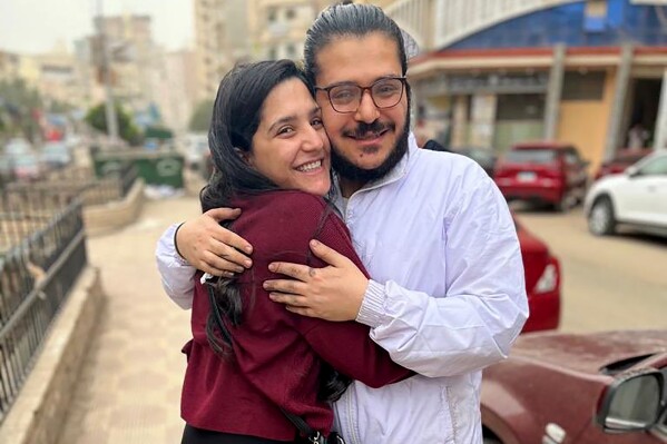 In this image provided by Egyptian Initiative for Personal Rights (EIPR), human rights activist Patrick George Zaki, who has been imprisoned for nearly two years, hugs his sister after his release outside the police station in Nile Delta city of Mansoura, Egypt, on Dec. 8, 2021. An Egyptian court has sentenced Patrick George Zaki to three years in prison over an opinion article he wrote in 2019. Egyptian Initiative for Personal Rights said the court on Tuesday, July 18, 2023 convicted Zaki of “disseminating false news” related to his article about alleged discrimination against Coptic Christians in Egypt. (EIPR via AP)