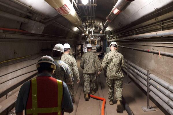 FILE - In this photo provided by the U.S. Navy, Rear Adm. John Korka, Commander, Naval Facilities Engineering Systems Command (NAVFAC), and Chief of Civil Engineers, leads Navy and civilian water quality recovery experts through the tunnels of the Red Hill Bulk Fuel Storage Facility, near Pearl Harbor, Hawaii, on Dec. 23, 2021. The U.S. Navy "harbored toxic secrets" when jet fuel contaminated drinking water for 93,000 military members and civilians in Hawaii, four families said in a lawsuit filed Wednesday, Aug. 31, 2022, claiming they continue to suffer maladies such as seizures, gastrointestinal disorders and neurological issues. (Mass Communication Specialist 1st Class Luke McCall/U.S. Navy via AP, File)