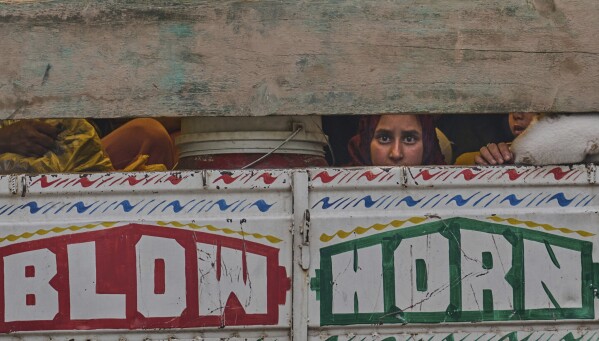 A Kashmiri woman looks from a truck as she along with her family members leave their village following overnight shelling from Pakistan at Gingal village in Uri district, Indian controlled Kashmir, Friday, May 9, 2025. (AP Photo/Dar Yasin)