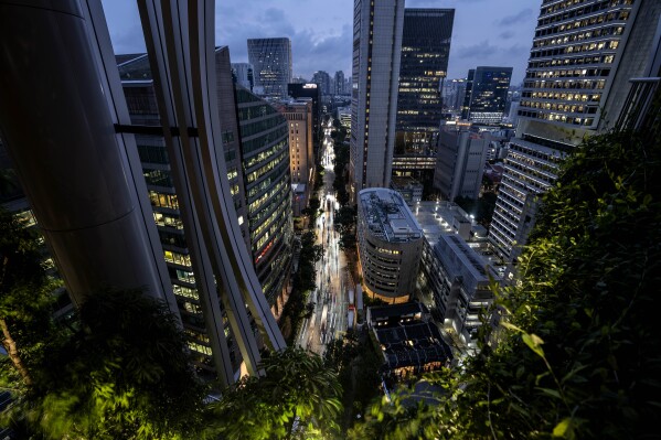 Rush hour traffic is seen from the Green Oasis botanical promenade at the CapitaSpring's skyscraper in Singapore, Thursday, July 20, 2023. The public green space spirals between levels 17 – 20 surrounded by downtown high-rises and features roughly 80,000 plants. (AP Photo/David Goldman)