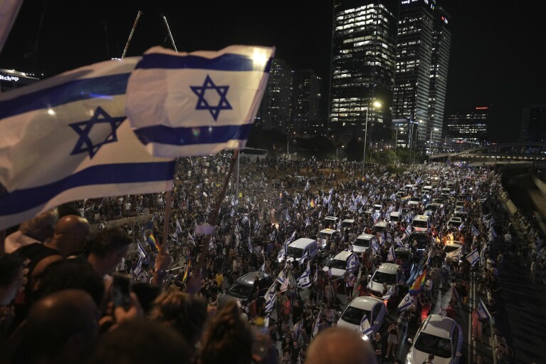 Demonstrators block the traffic on a highway crossing the city during a protest against plans by Netanyahu's government to overhaul the judicial system, in Tel Aviv, Monday, July 24, 2023. (AP Photo/Oded Balilty)