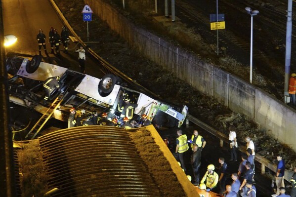 Emergency services attend the scene of a passenger bus accident near the city of Venice, Italy, that fell from an elevated road, late Tuesday, Oct. 3, 2023, near Venice, Italy. Italian authorities say multiple people have been killed and others injured in a bus crash near Venice. The crash happened Tuesday when the bus fell from an elevated street in the Mestre borough on the mainland opposite the old city of Venice. (Slow Press/LiveMedia/LaPresse via AP)