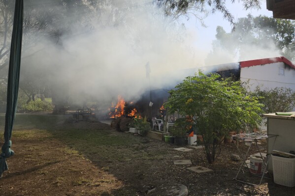 A house burns in Kibbutz Kfar Azza during a deadly attack on the community by Hamas militants from the Gaza Strip on Saturday, Oct. 7, 2023. (AP Photo/Hassan Eslaiah)