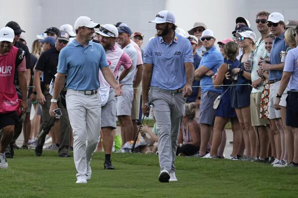 Rory McIlroy, of Northern Ireland,, left, and Max Homa, right, walk to the 15th green during the third round of the Tour Championship golf tournament at East Lake Golf Club Saturday, Aug. 27, 2022, in Atlanta. (AP Photo/Steve Helber)