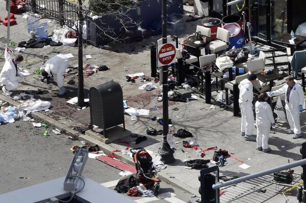 FILE - In this April 16, 2013, file photo, investigators examine the scene of the second bombing outside the Forum Restaurant on Boylston Street near the finish line of the 2013 Boston Marathon, a day after two blasts killed three and injured more than 260 people. The Biden administration's argument at the Supreme Court for reinstating the death penalty for convicted Boston Marathon bomber Dzhokhar Tsarnaev hinges on keeping evidence from the jury that prosecutors themselves relied on at an earlier phase of the proceedings. (AP Photo/Elise Amendola, File)