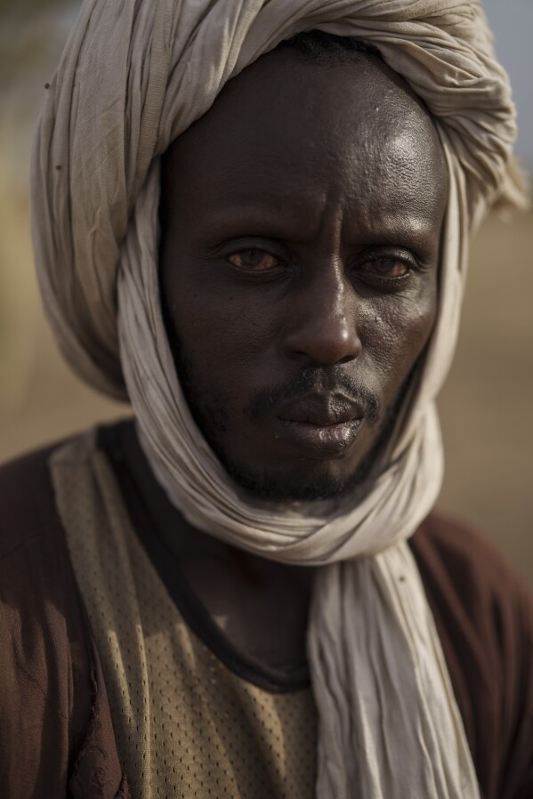 Oumar Abdoulaye Sow, stands for a portrait in the village of Fete Forrou, in the Matam region of Senegal, Tuesday, April. 11, 2023. For the 43-year-old, being a herder is something that the Fulani people have learned from their parents, raising livestock and agriculture, for generations. "The herd is our property and if it's well developed it allows us, for example, to buy a vehicle", explains Sow. (AP Photo/Leo Correa)