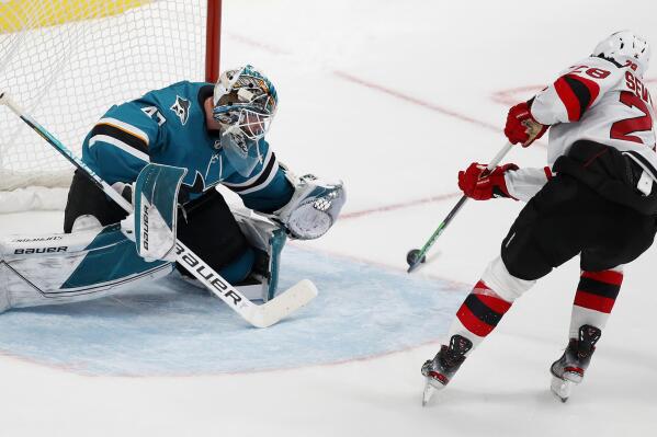 San Jose Sharks goaltender James Reimer (47) watches the puck as New Jersey Devils defenseman Damon Severson (28) shoots for a goal in the shootout of an NHL hockey game Saturday, Nov. 6, 2021, in San Jose, Calif. (AP Photo/Josie Lepe)