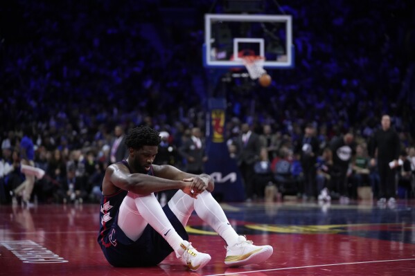 Philadelphia 76ers' Joel Embiid sits on the court during a timeout during the second half of an NBA basketball in-season tournament game against the Cleveland Cavaliers, Tuesday, Nov. 21, 2023, in Philadelphia. (AP Photo/Matt Slocum)