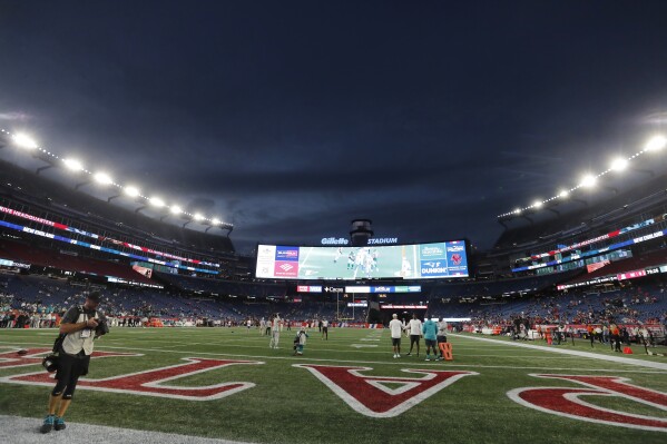 FILE — Lights illuminate Gillette Stadium before an NFL football game between the New England Patriots and the Miami Dolphins, Sunday, Sept. 17, 2023, in Foxborough, Mass. Police are investigating the death of a man following an "incident" in the stands at the New England Patriots home game Sunday. The Norfolk County district attorney's office says 53-year-old Dale Mooney, of Newmarket, N.H., "was in apparent need of medical attention." He was taken to a hospital, where he was pronounced dead. (AP Photo/Michael Dwyer, File)