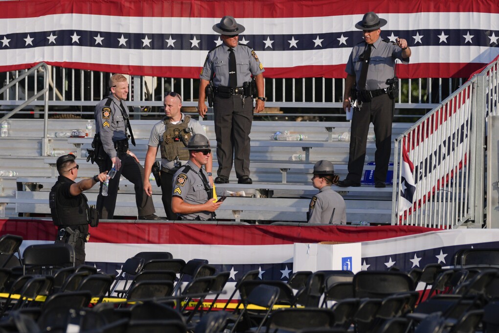 FILE - Law enforcement officers work at the campaign rally site for Republican presidential candidate former President Donald Trump is empty and littered with debris Saturday, July 13, 2024, in Butler, Pa. On Friday, July 19, ĢӰԺ reported on stories circulating online incorrectly claiming a law enforcement sniper assigned to Trump’s rally says the head of the Secret Service ordered him not to shoot the suspect accused of attempting to assassinate Trump.(ĢӰԺ Photo/Evan Vucci, File)