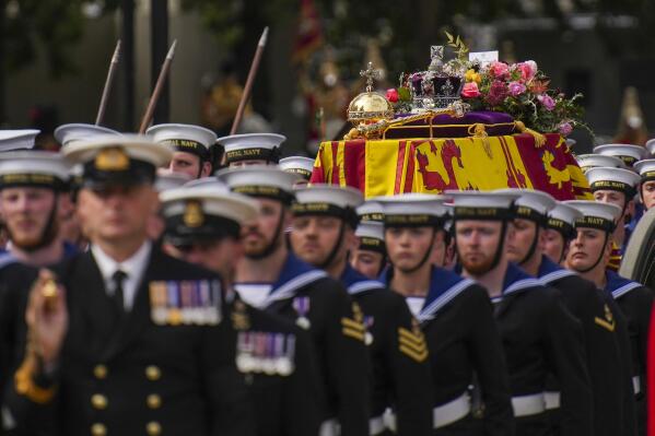 The coffin of Queen Elizabeth II is pulled on a gun carriage through the streets of London following her funeral service at Westminster Abbey, Monday Sept. 19, 2022.The Queen, who died aged 96 on Sept. 8, will be buried at Windsor alongside her late husband, Prince Philip, who died last year. (AP Photo/Emilio Morenatti,Pool)