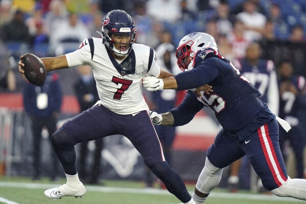 Houston Texans quarterback C.J. Stroud (7) tries to elude New England Patriots defensive tackle Daniel Ekuale, right, during the first half of an NFL preseason football game Thursday, Aug. 10, 2023, in Foxborough, Mass. (AP Photo/Steven Senne)
