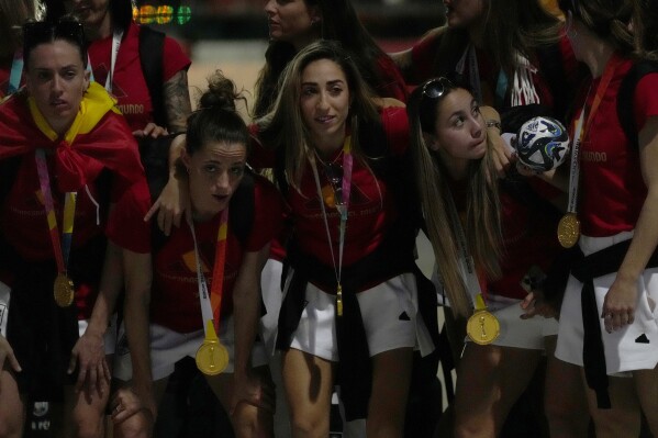 Spain's Olga Carmona, center, poses for a photo with members of the Spain's Women's World Cup soccer team as they arrive at Barajas international airport in Madrid, Spain, Monday, Aug. 21, 2023. Spain beat England in Sydney Sunday to win the Women's World Cup soccer final. (AP Photo/Paul White)