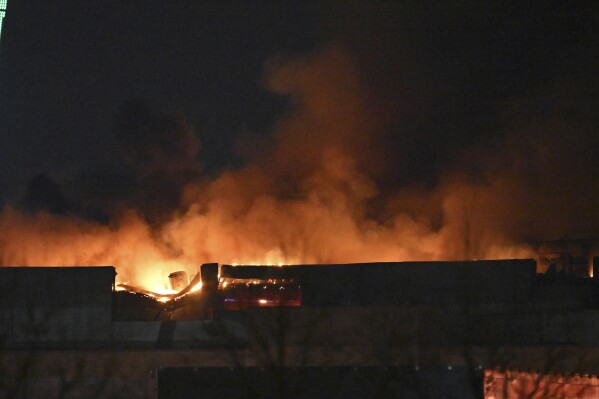 A massive blaze is seen over the Crocus City Hall on the western edge of Moscow, Russia, Friday, March 22, 2024. Several gunmen have burst into a big concert hall in Moscow and fired automatic weapons at the crowd, injuring an unspecified number of people and setting a massive blaze in an attack days after President Vladimir Putin cemented his grip on the country in a highly orchestrated electoral landslide. (AP Photo/Dmitry Serebryakov)