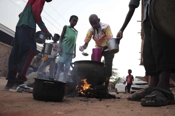 FILE - People prepare food in a Khrtoum neighborhood on June 16, 2023. Sudan’s warring parties began a cease-fire Sunday morning, June 18, 2023, after two months of fighting pushed the African nation into chaos. (AP Photo, File)