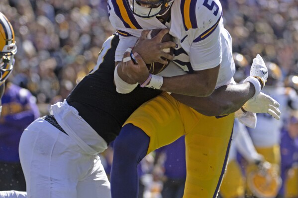 LSU quarterback Jayden Daniels (5) is hit by Missouri defensive back Daylan Carnell in the second half of an NCAA college football game Saturday, Oct. 7, 2023, in Columbia, Mo. (Hilary Scheinuk/The Advocate via AP)