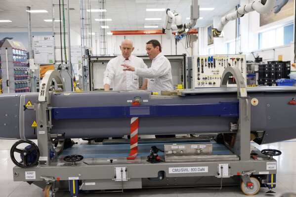 Director of Mechanical Engineering Matt Beamont shows Britain's Defence Secretary John Healey, left, a storm shadow missile on an assembly line at the MBDA Storm Shadow factory in Stevenage, England, Saturday May 31, 2025. (Dan Kitwood/Pool via AP)