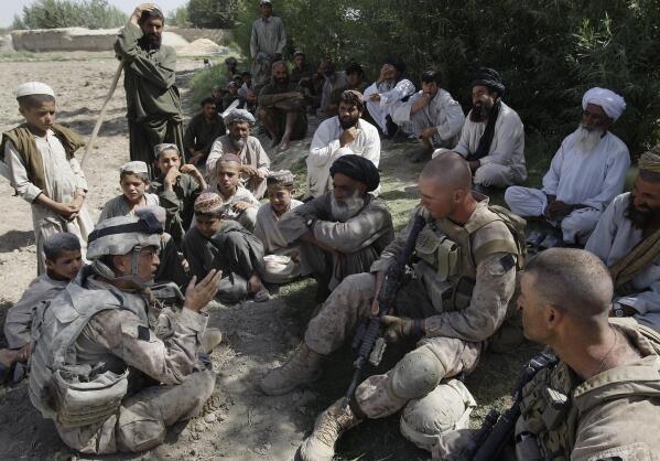 FILE - This July 2, 2009, photo shows Josh Habib, far left, a 53-year-old translator for the U.S. Marines, speaking with Afghan villagers and two Marines in the Nawa district of Afghanistan's Helmand province. More than 200 Afghans were due to land Friday, July 30, 2021 in the United States in the first of several planned evacuation flights for former translators and others as the U.S. ends its nearly 20-year war in Afghanistan. (AP Photo/David Guttenfelder)