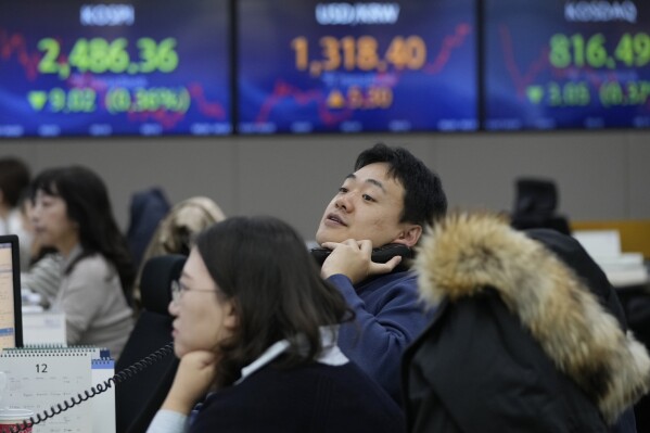 A currency watches monitors at the foreign exchange dealing room of the KEB Hana Bank headquarters in Seoul, South Korea, Thursday, Dec. 7, 2023. Shares fell Thursday in Asia after a retreat on Wall Street as crude oil prices slipped on expectations that supply might outpace demand. (APPhoto/Ahn Young-joon)