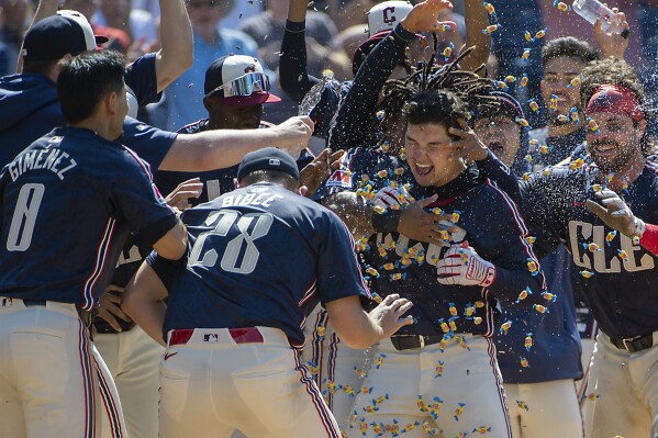 Cleveland Guardians' Andres Gimenez, Tanner Bibee and their teammates congratulate Will Brennan, center, after hitting a walk-off three-run home run off Minnesota Twins relief pitcher Jhoan Duran at the end of a baseball game in Cleveland, Sunday, May 19, 2024. (AP Photo/Phil Long)
