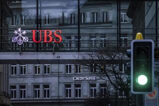 FILE - A traffic light signals green in front of the logos of the Swiss banks Credit Suisse and UBS in Zurich, Switzerland, on March 19, 2023. Swiss banking giant UBS said Tuesday it took in $28 billion of net new money for its wealth management business in the first quarter, with $7 billion of that coming in the days after the announcement of its government-backed takeover of ailing rival Credit Suisse. (Michael Buholzer/Keystone via AP, File)