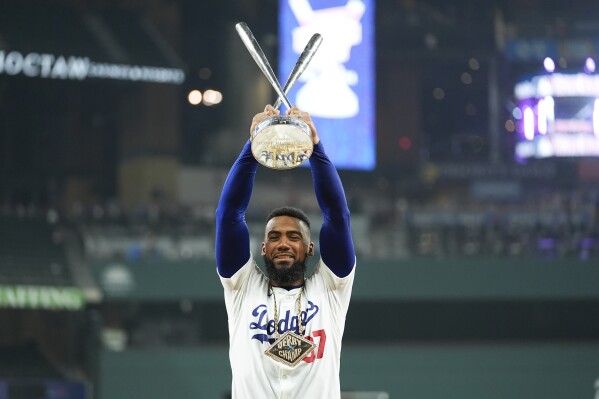 National League's Teoscar Hernández, of the Los Angeles Dodgers, poses for photos with the winner's trophy after the MLB baseball All-Star Home Run Derby, Monday, July 15, 2024, in Arlington, Texas. (AP Photo/Julio Cortez)