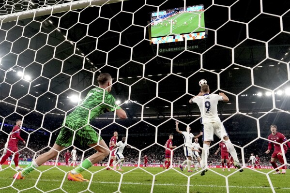 England's Harry Kane, right, saves a shot on goal during a Group C match between Serbia and England at the Euro 2024 soccer tournament in Gelsenkirchen, Germany, Sunday, June 16, 2024. (AP Photo/Martin Meissner)