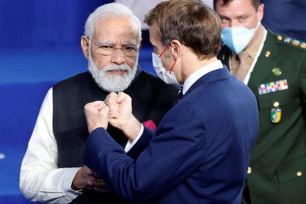 French President Emmanuel Macron, right, speaks with India's Prime Minister Narendra Modi during a group photo at the La Nuvola conference center for the G20 summit in Rome, Saturday, Oct. 30, 2021. The two-day Group of 20 summit is the first in-person gathering of leaders of the world's biggest economies since the COVID-19 pandemic started. (Ludovic Marin, Pool Photo via AP)