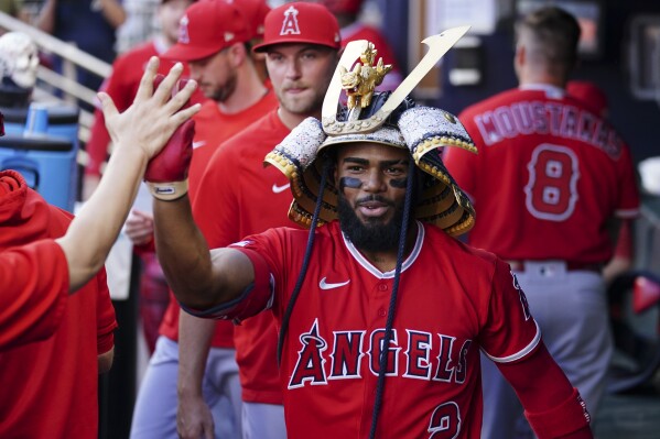 Shohei Ohtani of the Los Angeles Angels celebrates wearing a samurai  warrior helmet in the dugout after hitting a two-run home run in the third  inning of a baseball game against the