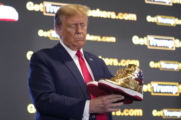 Republican presidential candidate former President Donald Trump holds gold Trump sneakers at Sneaker Con Philadelphia, an event popular among sneaker collectors, in Philadelphia, Saturday, Feb. 17, 2024. (APPhoto/Manuel Balce Ceneta)