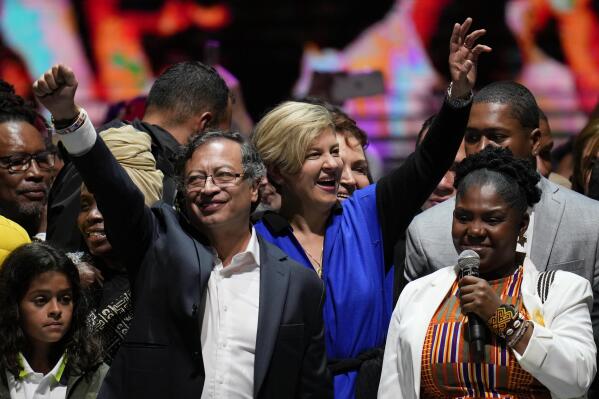 Former rebel Gustavo Petro, left, his wife Veronica Alcocer, back center, and his running mate Francia Marquez, celebrate before supporters after winning a runoff presidential election in Bogota, Colombia, Sunday, June 19, 2022. (AP Photo/Fernando Vergara)