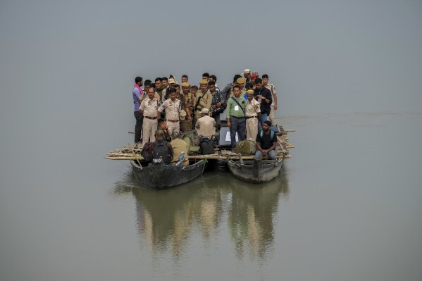 Polling officials and security personnel headed to a remote polling booth travel on a boat to cross the river Brahmaputra on the eve of parliament election at Baghmora Chapori (small island) of Majuli, northeastern Assam, India, April 18, 2024. (AP Photo/Anupam Nath)