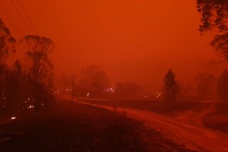 In this Dec. 31, 2019, photo provided by Siobhan Threlfall, fire and thick smoke remains the village of Nerrigundah, Australia. The tiny village has been among the hardest hit by Australia's devastating wildfires, with about two thirds of the homes destroyed and a 71-year-old man killed. (AP Photo/Siobhan Threlfall)