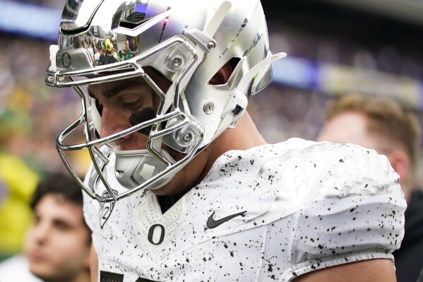 Oregon quarterback Bo Nix walks to the locker room after the first half of an NCAA college football game against Washington, Saturday, Oct. 14, 2023, in Seattle. (AP Photo/Lindsey Wasson)