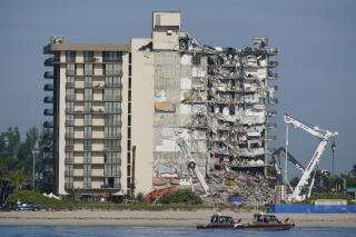 FILE - In this July 1, 2021, file photo, Coast Guard boats patrol in front of the partially collapsed Champlain Towers South condo building in Surfside, Fla. A judge pushed on Wednesday, Oct. 20, 2021, for compromise on potential payouts between people who lost loved ones and those whose units were destroyed in the deadly collapse of a Florida beachfront condominium. (AP Photo/Mark Humphrey, File)