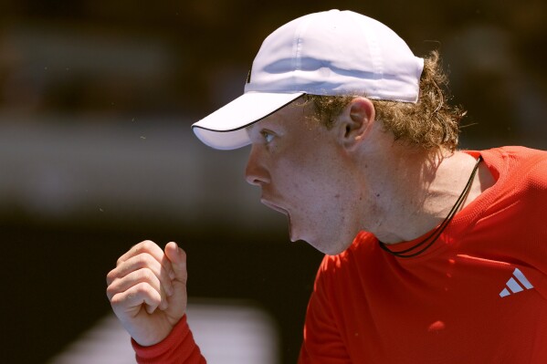 Alex Michelsen of the U.S. reacts after winning a point against Stefanos Tsitsipas of Greece during their first round match at the Australian Open tennis championship in Melbourne, Australia, Monday, Jan. 13, 2025. (AP Photo/Ng Han Guan)