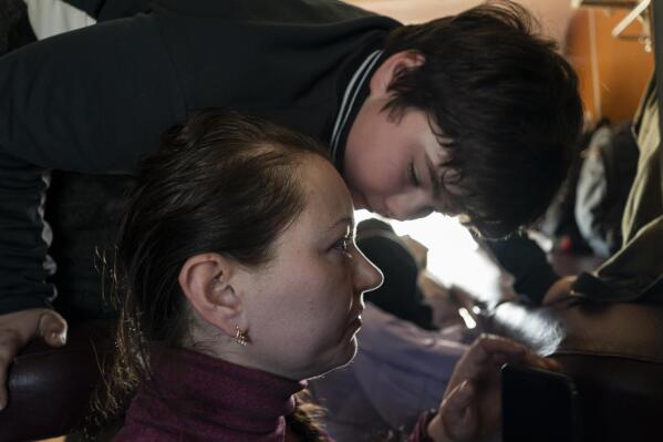 Marina Galla and her son, who both scaped from the besieged city of Mariupol onboard a Zaporizhzhia-Lviv train in western Ukraine, on Sunday, March 20, 2022. (AP Photo/Bernat Armangue)