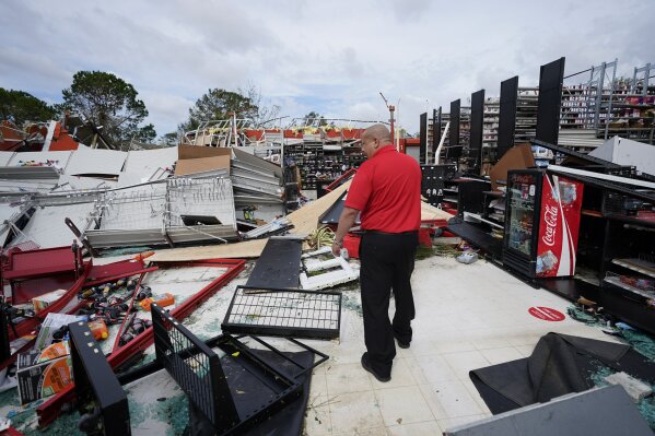 An auto parts store employee surveys the damage to the facilty on Thursday, Aug. 27, 2020, in Lake Charles, La., in the aftermath of Hurricane Laura. (AP Photo/Gerald Herbert)