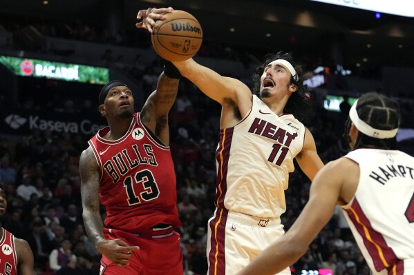 Chicago Bulls forward Torrey Craig (13) and Miami Heat guard Jaime Jaquez Jr. (11) go for the ball during the second half of an NBA basketball game, Thursday, Dec. 14, 2023, in Miami. (AP Photo/Lynne Sladky)