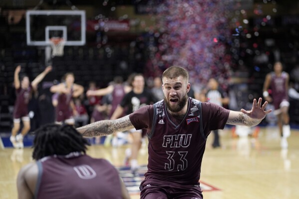 Freed-Hardeman forward Devin Tomlinson (33) celebrates after a NAIA men's national championship college basketball game against Langston, Tuesday, March 26, 2024, in Kansas City, Mo. Freed-Hardeman won 71-67. (AP Photo/Charlie Riedel)
