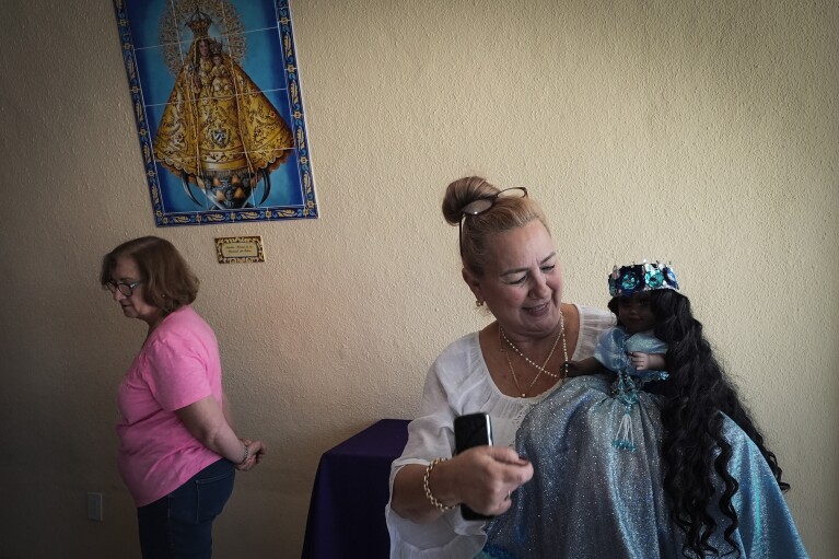Barbara Ruiz holds her Yoruba religion’s deity "Yamaya," associated with The Virgin of Regla, at Our Lady of Charity shrine, known as La Ermita, during an Ash Wednesday Mass in Miami, Florida. (AP Photo/Marta Lavandier)