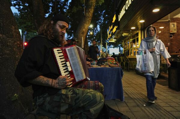 A street musician plays music on a sidewalk in northern Tehran, Iran, Wednesday, April 30, 2025. (AP Photo/Vahid Salemi)