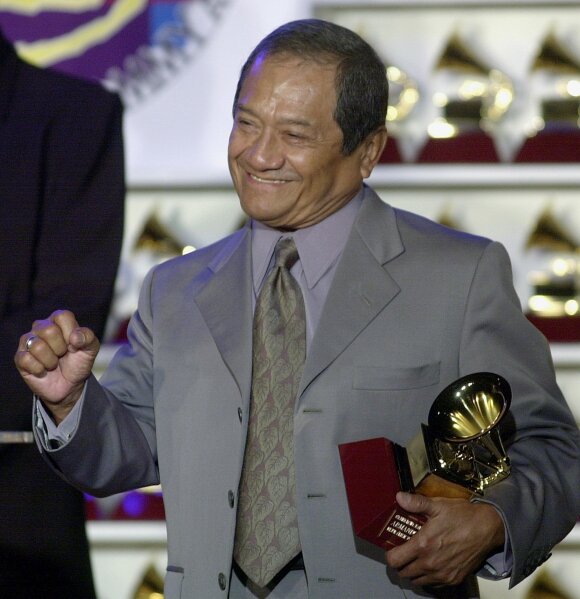 FILE - In this Oct. 30, 2001 file photo, Armando Manzanero holds his Latin Grammy Award for Best Pop Album by a Duo or Group with Vocals, for "Duetos," at a press conference in Los Angeles. The Mexican master of romantic music who penned Spanish classics such as “Somos Novios” and “Contigo Aprendí,” has died, according to Mexico's President Andrés Manuel López Obrador on Monday, Dec. 28, 2020.  (AP Photo/Nick Ut, File)