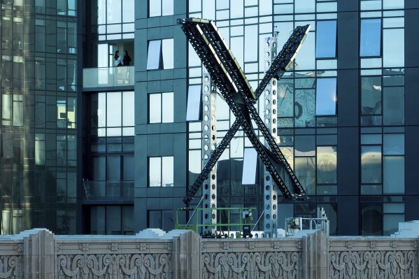 A partially completed "X" sign rests atop the company headquarters, formerly known as Twitter, in downtown San Francisco, on Friday, July 28, 2023. San Francisco has launched an investigation into the sign as city officials say replacing letters or symbols on buildings, or erecting a sign on top of one, requires a permit. (AP Photo/Noah Berger)