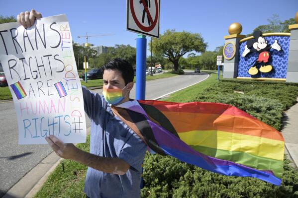 Disney cast member Nicholas Maldonado protests his company's stance on LGBTQ issues, while participating in an employee walkout at Walt Disney World, Tuesday, March 22, 2022, in Lake Buena Vista, Fla. (AP Photo/Phelan M. Ebenhack)