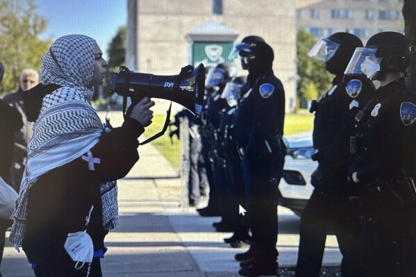 Protesters chant in front of a line of Wayne State police officers shortly after university authorities removed a pro-Palestinian encampment from campus on Thursday, May 30, 2024, in Detroit. (Marnie Munoz/Detroit News via AP)