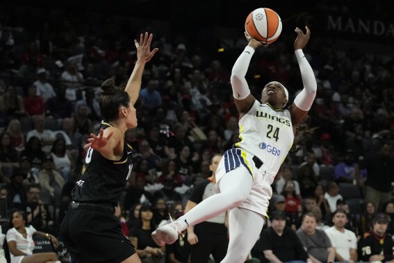 Dallas Wings guard Arike Ogunbowale (24) shoots over Las Vegas Aces guard Kelsey Plum (10) during the second half in Game 2 of a WNBA basketball semifinal series Tuesday, Sept. 26, 2023, in Las Vegas. (AP Photo/John Locher)