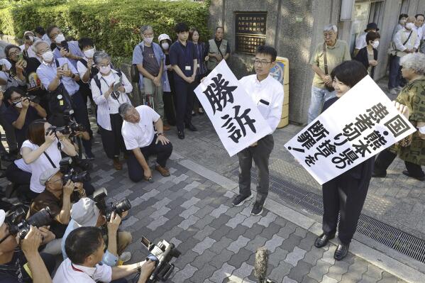 Abogados sostienen letreros con la palabra "Victoria" en japonés luego del veredicto en el tribunal de distrito de Osaka, en el oeste de Japón, el miércoles 27 de septiembre de 2023. (Kyodo News vía AP)
