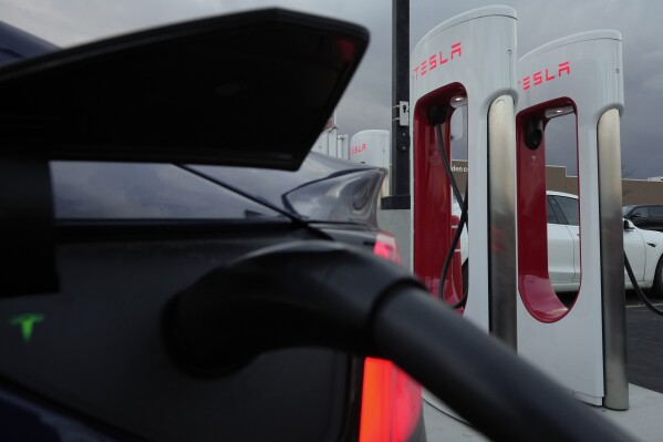 FILE - A vehicle charges at a Tesla Supercharger station in Detroit, Nov. 16, 2022. Elon Musk’s move to lay off the department responsible for Tesla’s electric vehicle charging network has touched off worries in the auto industry about plans to open the chargers to EVs made by other automakers. Several leaders of Tesla’s Supercharger team posted social media messages saying they were told Monday, April 29, 2024 that entire group of about 500 had been eliminated by CEO Musk. (AP Photo/Paul Sancya, File)