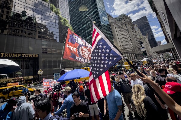 A supporter of former President Donald Trump waves an inverted American flag during a demonstration outside Trump Tower, Friday, May 31, 2024, in New York. A day after a New York jury found Trump guilty of 34 felony charges, the presumptive Republican presidential nominee addressed the conviction and likely attempt to cast his campaign in a new light. (AP Photo/John Minchillo)